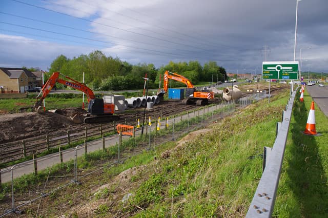 Excavators and concrete drainage pipes on a UK highways construction site.